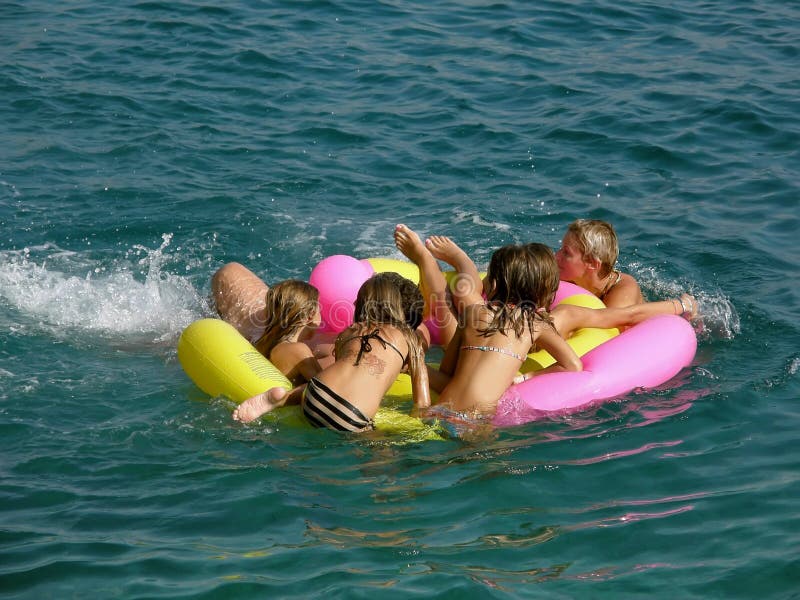 Families (father,mother and children - best friends - relationship) in the crowd, floating on air beach toys on relaxing, have a fun at summer holiday in Adriatic sea (Croatia - Dalmatia). Horizontal color photo. Families (father,mother and children - best friends - relationship) in the crowd, floating on air beach toys on relaxing, have a fun at summer holiday in Adriatic sea (Croatia - Dalmatia). Horizontal color photo.
