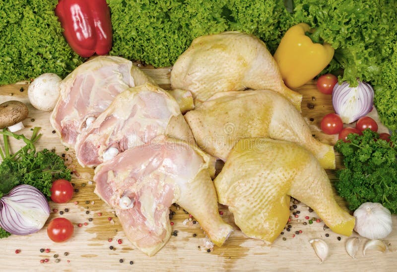 Six pieces of chicken legs with cherry tomatoes, lettuce leaves, garlic, chilli pepper, rosemary, onion royalty free stock photography Six pieces of chicken legs with cherry tomatoes, lettuce leaves, garlic, chilli pepper, rosemary, onion royalty free stock photography