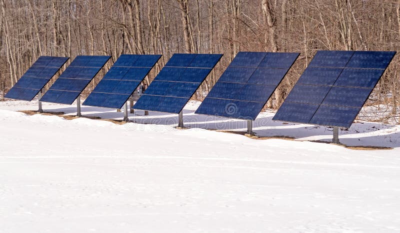 Row of six solar power panels in white snow for electric power, upstate rural New York winter. Row of six solar power panels in white snow for electric power, upstate rural New York winter
