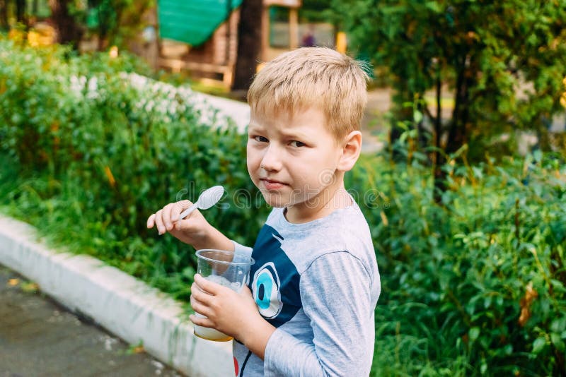 Six-year-old boy eats a plastic spoon useful oxygen cocktail stock photography Six-year-old boy eats a plastic spoon useful oxygen cocktail stock photography