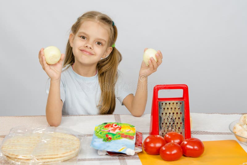 Six Year Old Girl at Kitchen Table Having Fun Holding Vegetables Stock