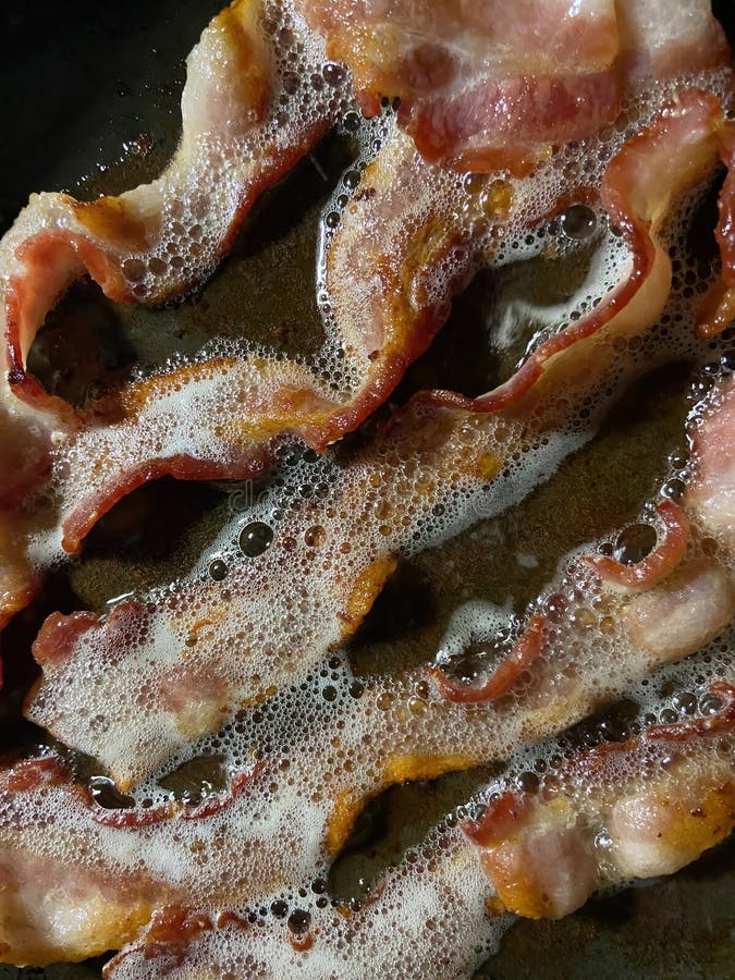 Photo of sizzling bacon in frying pan being cooked for breakfast. Frying pan stock images, royalty-free photos and pictures