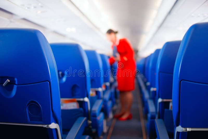 Siège de passager, intérieur d'avion avec des passagers s'asseyant sur des sièges et hôtesse marchant le bas-côté à l'arrière-pla images stock Siège de passager, intérieur d'avion avec des passagers s'asseyant sur des sièges et hôtesse marchant le bas-côté à l'arrière-pla images stock
