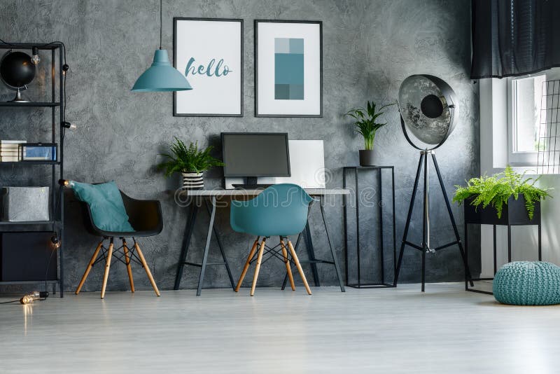 Blue chair, pouf and designer lamp in stylish home office with posters on concrete wall. Blue chair, pouf and designer lamp in stylish home office with posters on concrete wall