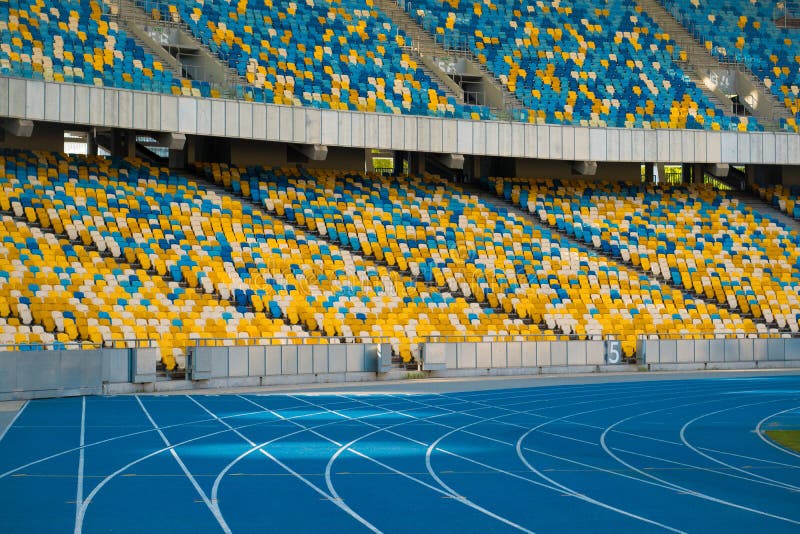 Sièges colorés vides de stade et voies courantes image stock Sièges colorés vides de stade et voies courantes image stock