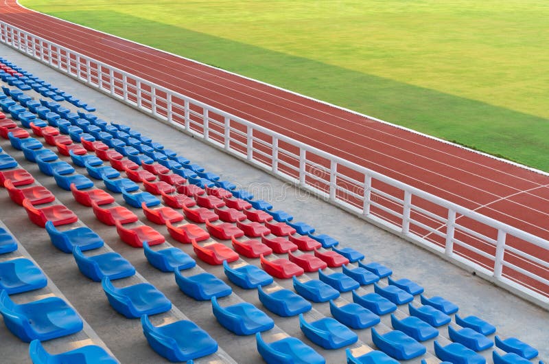 Sièges vides dans l'arène grande du football de terrain de football avec les voies fonctionnantes dans le stade de sport photo stock Sièges vides dans l'arène grande du football de terrain de football avec les voies fonctionnantes dans le stade de sport photo stock