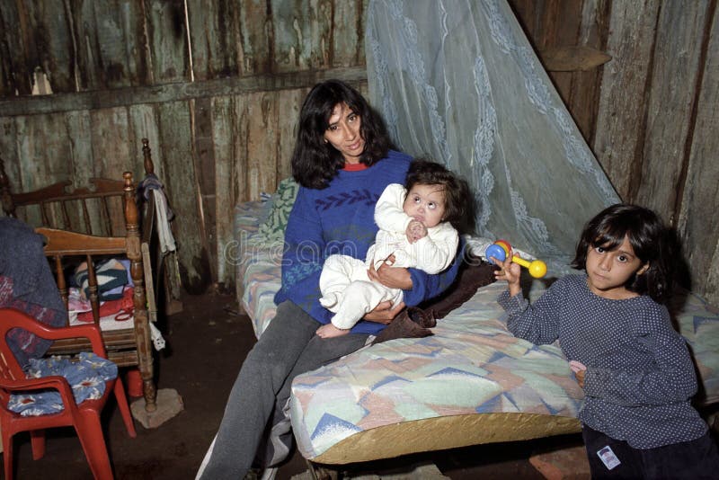 Argentina, Jujuy province, mother with two children in her one-room shack in the slum Los Jesuitas in the place Colonia Santa Rosa. In this slum poverty is so great that many people are malnourished. Argentina, Jujuy province, mother with two children in her one-room shack in the slum Los Jesuitas in the place Colonia Santa Rosa. In this slum poverty is so great that many people are malnourished.