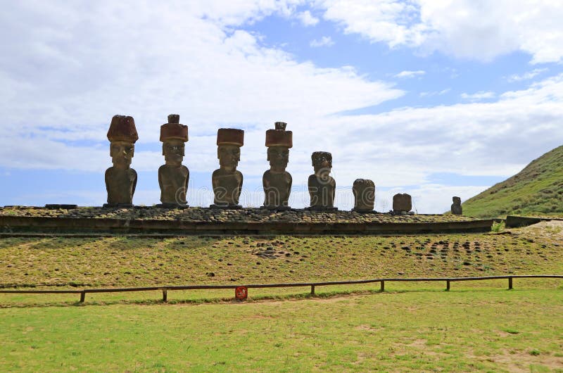 Sju Moai statyer av Ahu Nau Nau med enkla Moai av Ahu Ature Huki i bakgrunden, Anakena strand, påskö, Chile royaltyfria foton