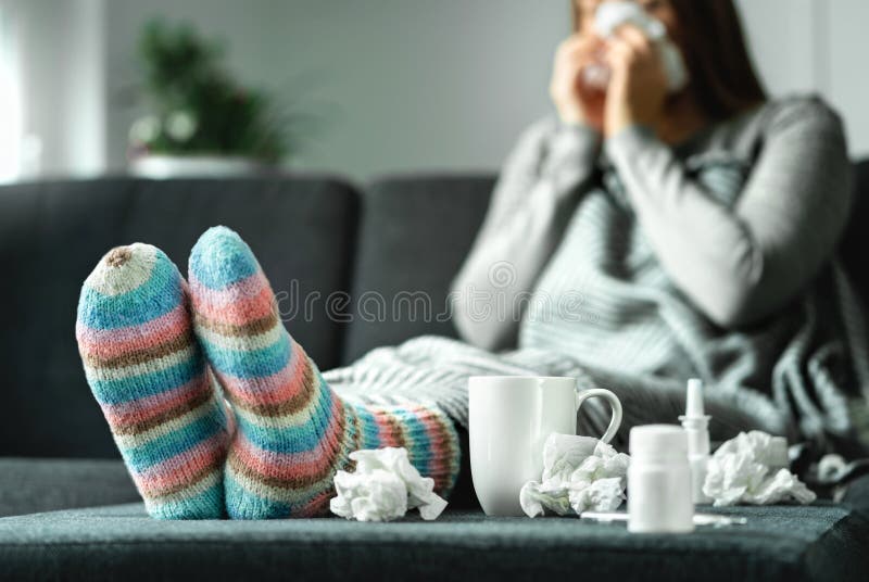 Sjuk kvinna med influensa, förkylning, feber och hosta som hemma sitter på soffan Dåligt blåsa näsa för person och nysa med silke royaltyfria bilder