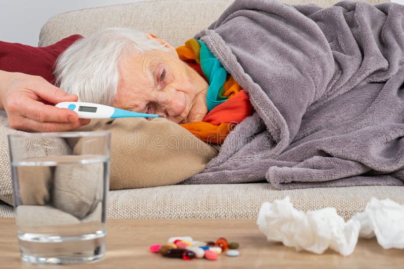Sjuk äldre kvinna på soffan arkivbild Sjuk äldre kvinna på soffan arkivbild