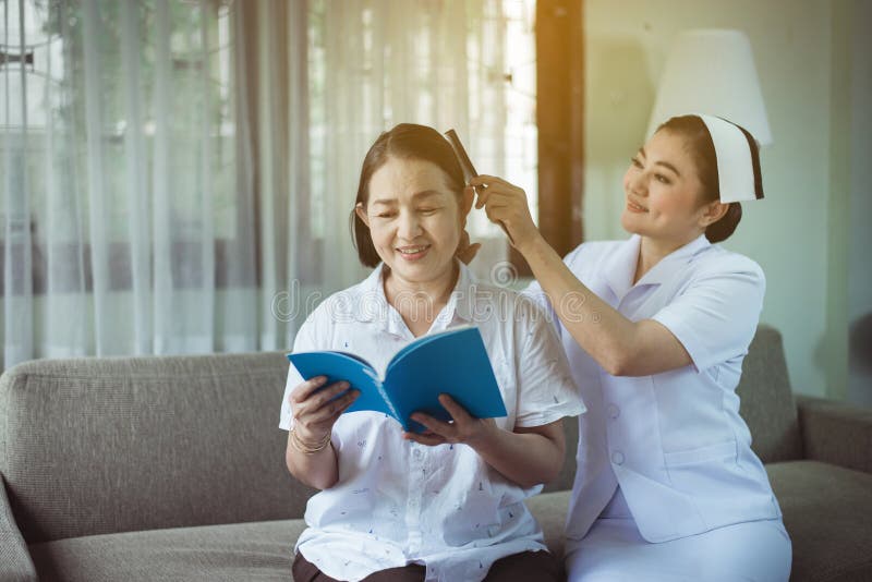 Sjuksköterska eller vårdgivare som använder kombination med hårvårdsäldre, asiatisk patient, vårdkoncept i hemmet arkivbilder Sjuksköterska eller vårdgivare som använder kombination med hårvårdsäldre, asiatisk patient, vårdkoncept i hemmet arkivbilder