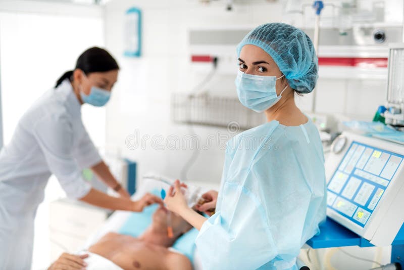 Sjuksköterska i steril enhetlig hållande respiratorisk utrustning fotografering för bildbyråer Sjuksköterska i steril enhetlig hållande respiratorisk utrustning fotografering för bildbyråer
