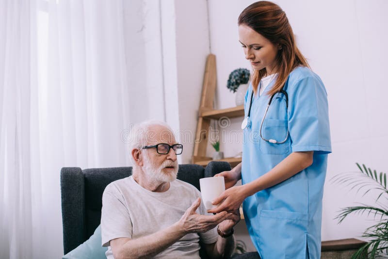 Sjuksköterska som hjälper den höga patienten att rymma fotografering för bildbyråer Sjuksköterska som hjälper den höga patienten att rymma fotografering för bildbyråer
