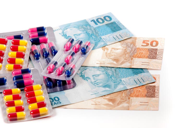 Assorted pills and capsules over brazilian money. Assorted pills and capsules over brazilian money