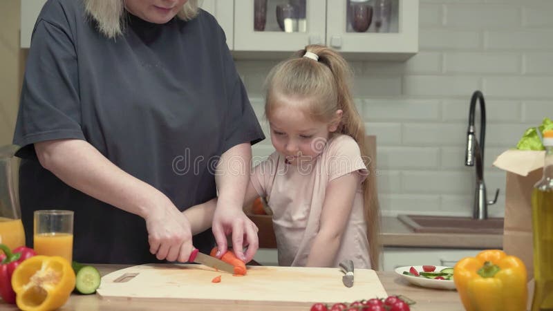 Sjukvårdsmamma och dotter kokar hälsosamma måltider arkivfilmer