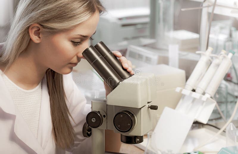 Sk?nhetforskare Looks i mikroskop i kemiskt laboratorium arkivbild Sk?nhetforskare Looks i mikroskop i kemiskt laboratorium arkivbild