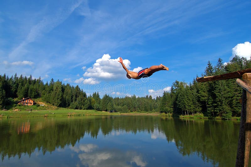 Young boy jumping in alpine lake in Slovenia. Young boy jumping in alpine lake in Slovenia