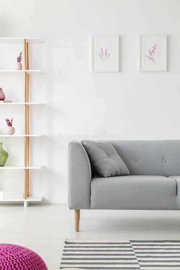 Skandinavisch woonkamerontwerp met grijze laag, verwarmerdrukken op de muur en de houten plank met vazen op het royalty-vrije stock afbeeldingen Skandinavisch woonkamerontwerp met grijze laag, verwarmerdrukken op de muur en de houten plank met vazen op het royalty-vrije stock afbeeldingen