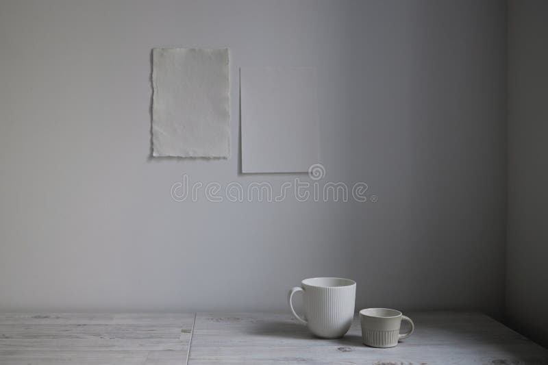 Scandinavian style. Interior Design. A white cups is on the table. Two blank sheets of paper are attached to the wall. Empty space for text. Scandinavian style. Interior Design. A white cups is on the table. Two blank sheets of paper are attached to the wall. Empty space for text