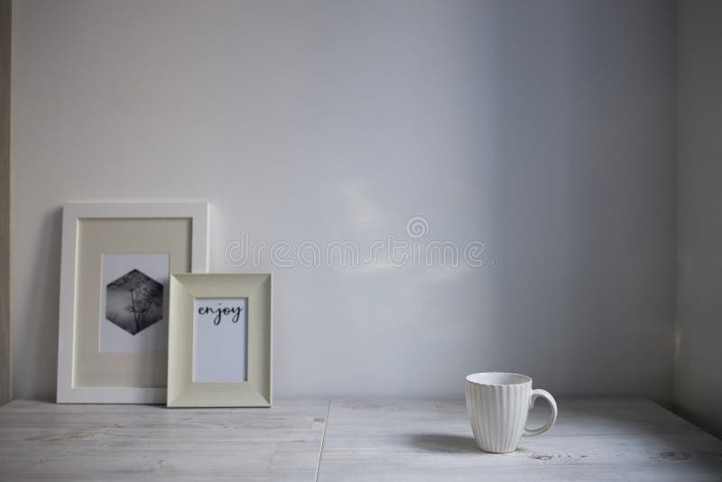 Scandinavian style. Interior Design. A white cup, a two frame for a photo are on the table. Empty space for text. Scandinavian style. Interior Design. A white cup, a two frame for a photo are on the table. Empty space for text