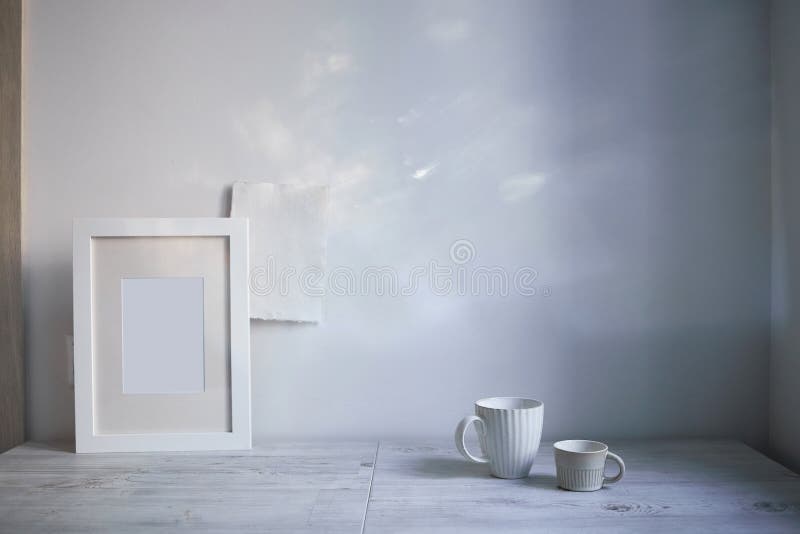 Scandinavian style. Interior Design. A white cup of different size, a frame for a photo are on the table. Empty space for text. Scandinavian style. Interior Design. A white cup of different size, a frame for a photo are on the table. Empty space for text
