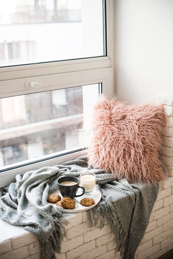 Skandinavisk stilfrukost, kopp kaffe och kakor på hemtrevlig fönsterbräda med den varma filten och kudden arkivfoto Skandinavisk stilfrukost, kopp kaffe och kakor på hemtrevlig fönsterbräda med den varma filten och kudden arkivfoto