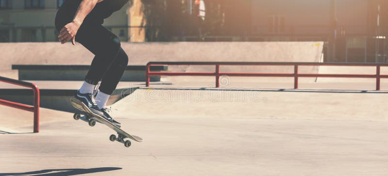 Skateboard fahren - Skateboardfahrer, der den Trick springt am Stadtrochenpark tut