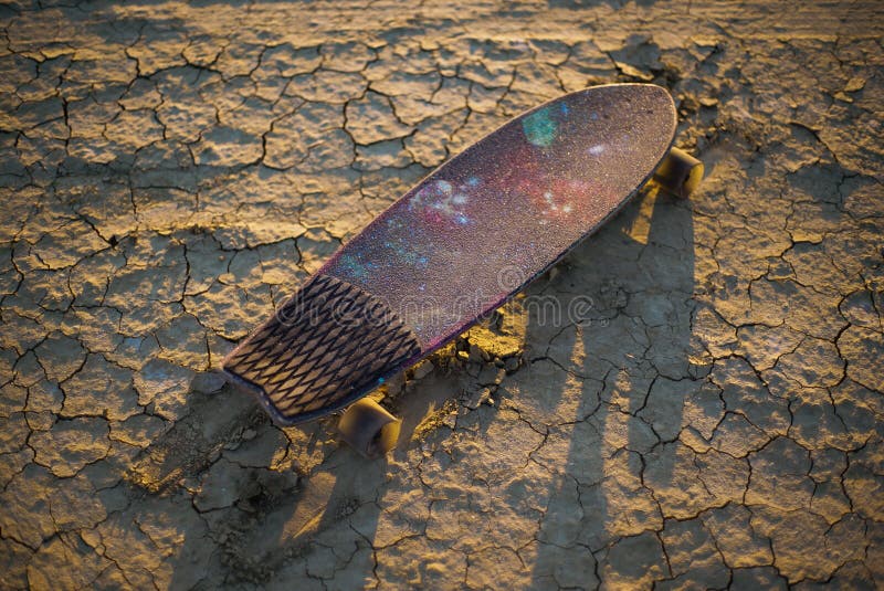 Skateboard oder longboard fest im Sand in der Wüste bei Sonnenuntergang stockfotografie Skateboard oder longboard fest im Sand in der Wüste bei Sonnenuntergang stockfotografie