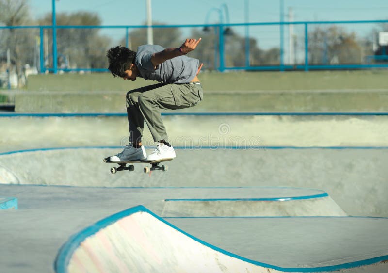 Skateboarder suspended in the air above the concrete of skatepark