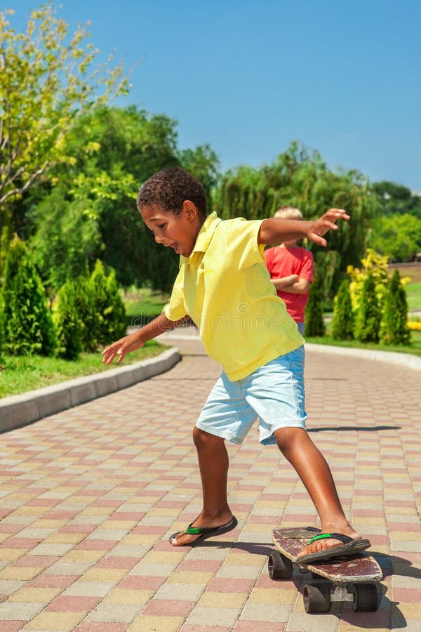 Boy inappropriate footwear trying to learn skateboarding