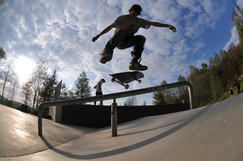 Skateboarder flying high at the skate park in summertime. Skateboarder flying high at the skate park in summertime.