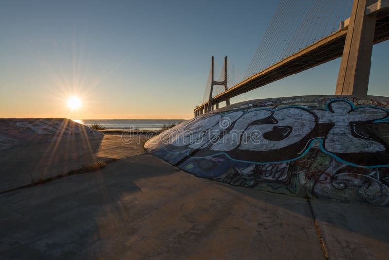 Skatepark на Vasco de Gama Мосте в Лиссабоне во время восхода солнца Подземный парк конька на Ponte Vasco de Gama стоковые изображения rf Skatepark на Vasco de Gama Мосте в Лиссабоне во время восхода солнца Подземный парк конька на Ponte Vasco de Gama стоковые изображения rf