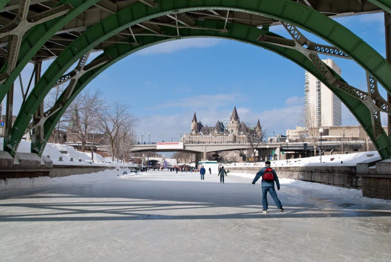 Skaters on the rideau canal, a UNESCO heritage site, in winter, pass under the Laurier Street bridge.