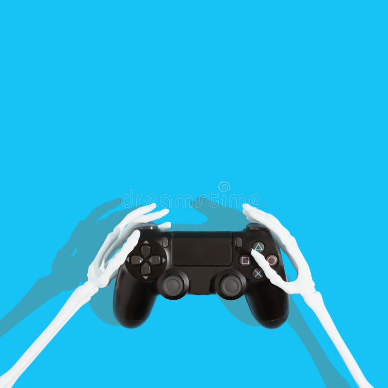 Skeleton hands holding black video game controller. Light blue background. Copy space. Minimal gaming concept