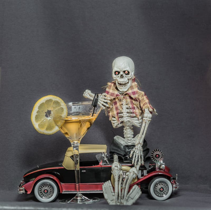 Skeletzitting op klassieke de autosleutels van de autoholding en alcoholdrank royalty-vrije stock foto's Skeletzitting op klassieke de autosleutels van de autoholding en alcoholdrank royalty-vrije stock foto's