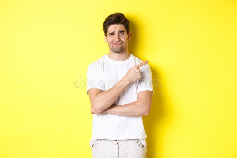 Skeptical and Unamused Man Pointing Finger Right at Something Lame,  Frowning Reluctant, Standing Over Yellow Background Stock Image - Image of  person, caucasian: 229169715