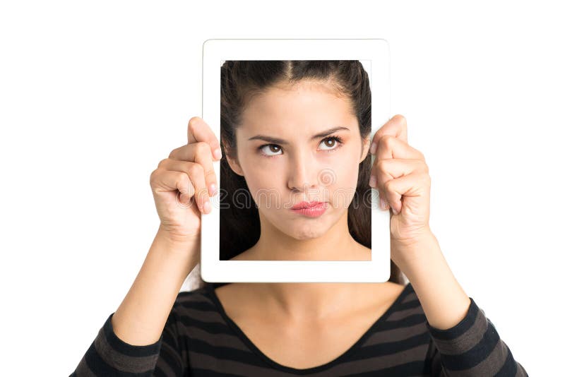 Isolated image of a young girl holding a tablet with a skeptical face over white. Isolated image of a young girl holding a tablet with a skeptical face over white