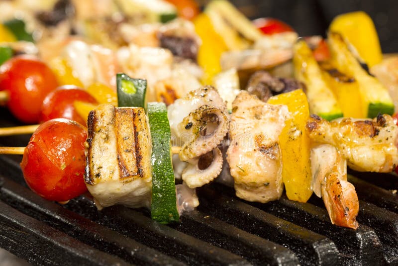 Skewers of seafood grilling