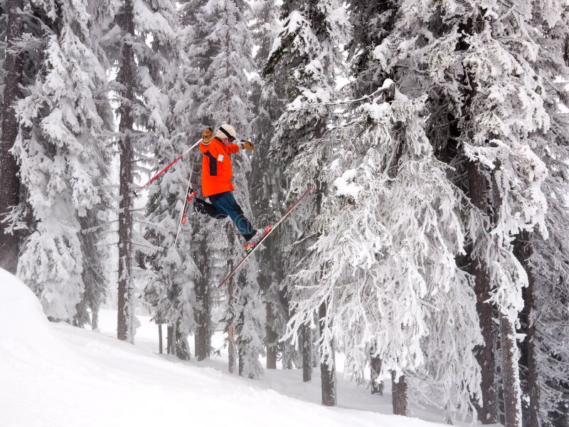 Esquiador en naranja chaqueta tiene de de esquiar saltar antes la nieve cubierto árboles.