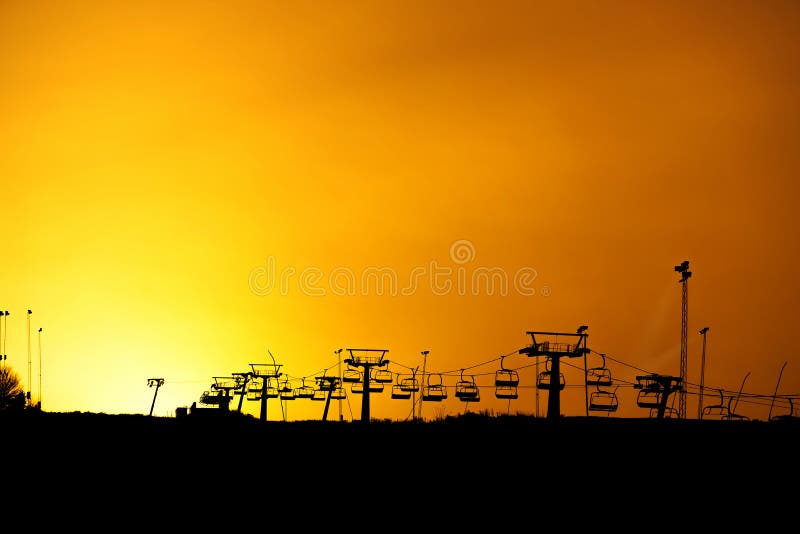 Ski lift silhouette with yellow sky