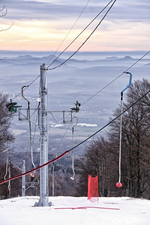 Ski Lift on the Snow Covered Hill Above the Cloudy Panaroma of Hills