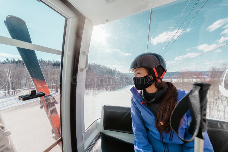 Ski resorts open for winter sports following coronavirus restriction guidelines. Woman tourist wearing face mask inside