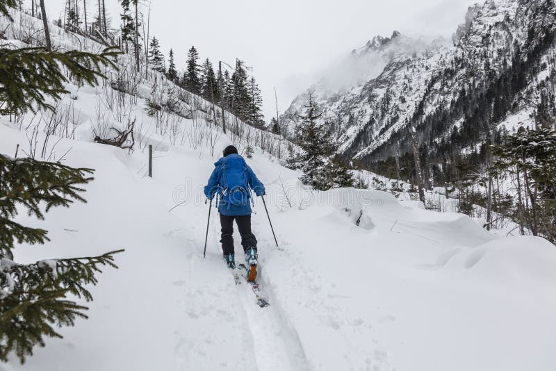 Ski-tour guide leads the group in an avalanche-dangerous backcountry area in snowy High Tatras, Slovakia