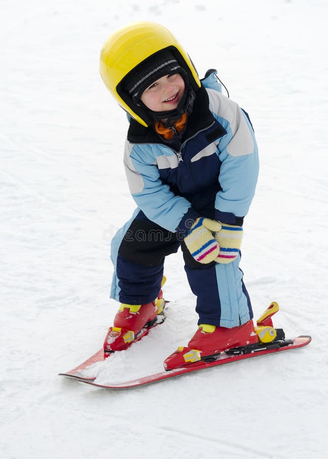 Child learning to ski in winter skiing resort practicing the correct moves. Child learning to ski in winter skiing resort practicing the correct moves.