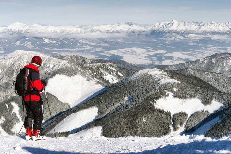 Skier looking at snowy winter mountains