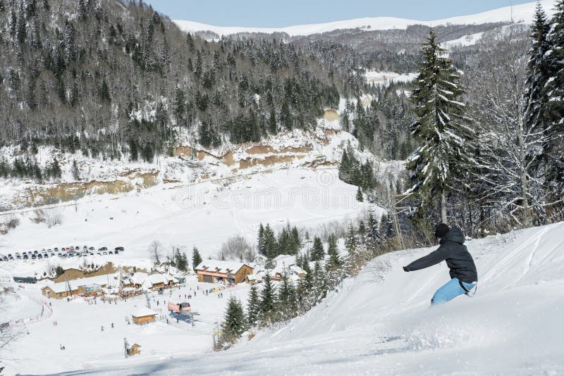 Skier skiing in fresh snow on ski in the mountains on a sunny winter day in Montenegro