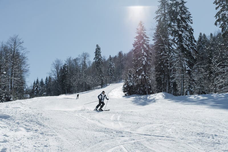 Skier skiing in fresh snow on ski in the mountains on a sunny winter day in Montenegro