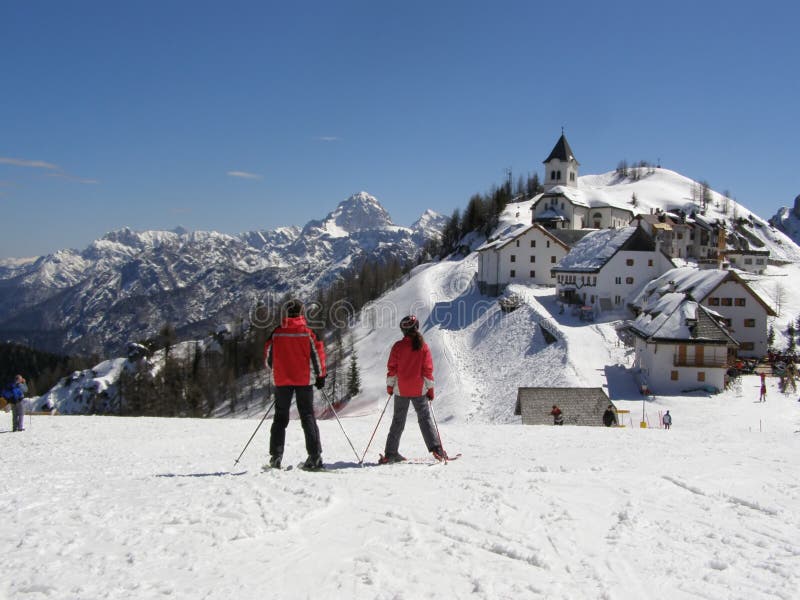 Skiers and alpine village panorama
