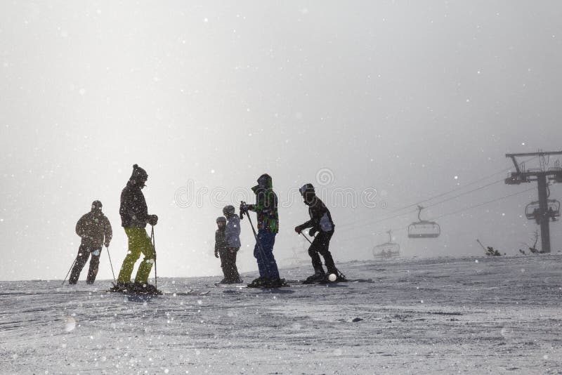 Skiers on ski slopes in fog.