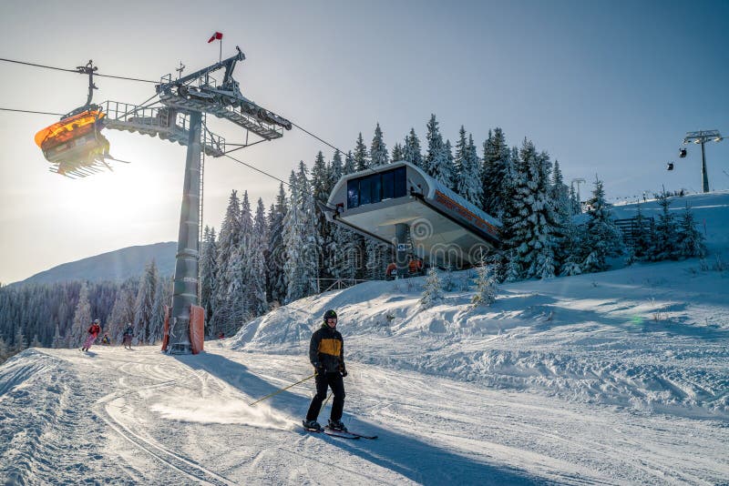 Skiers on slope and ski lift chair at resort Jasna, Slovakia